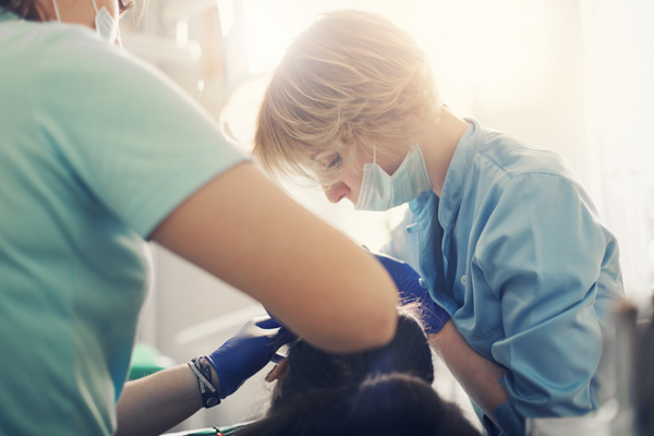 Dentist and assistant performing dental procedure.